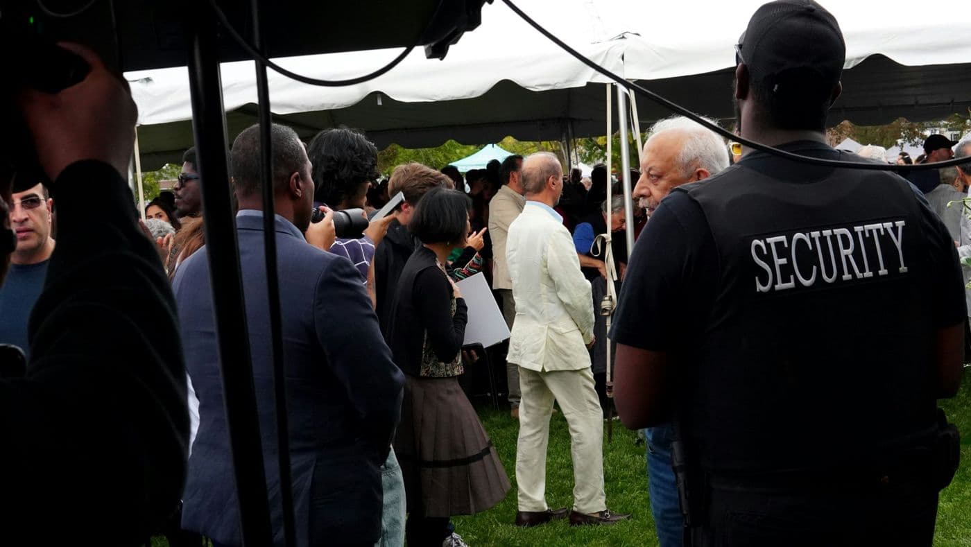 Security officer seen from behind at an outdoor event under marquees