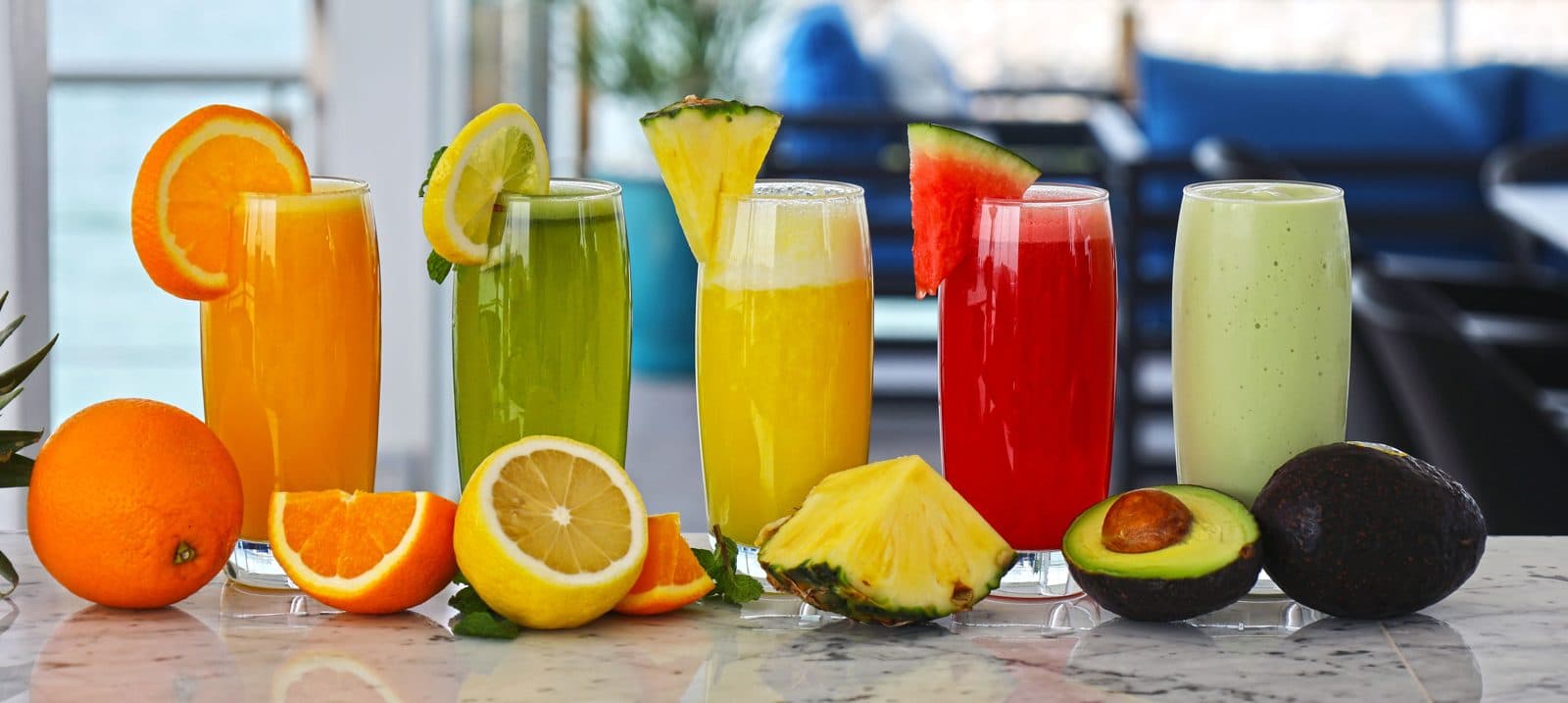 Colourful juices and smoothies lined up with fresh fruit