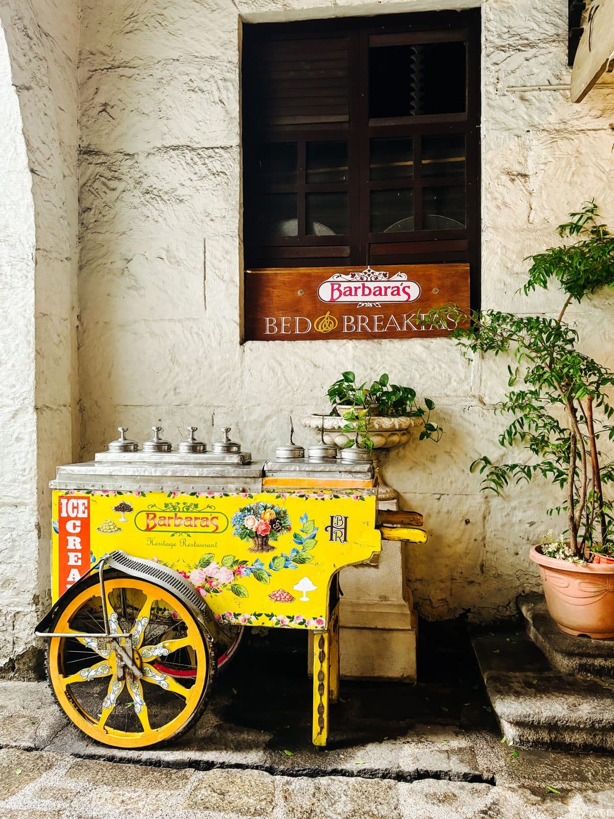 Chariot à glaces jaune devant une façade en pierre