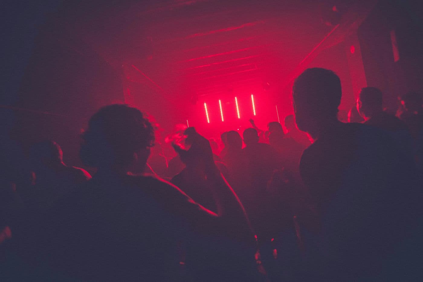Dance floor bathed in red light during a DJ set