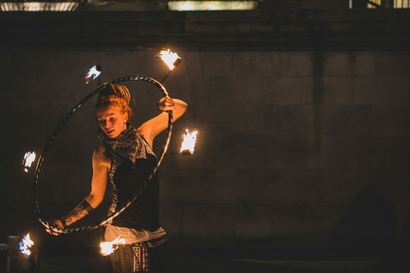 Performer spinning a flaming hoop at night
