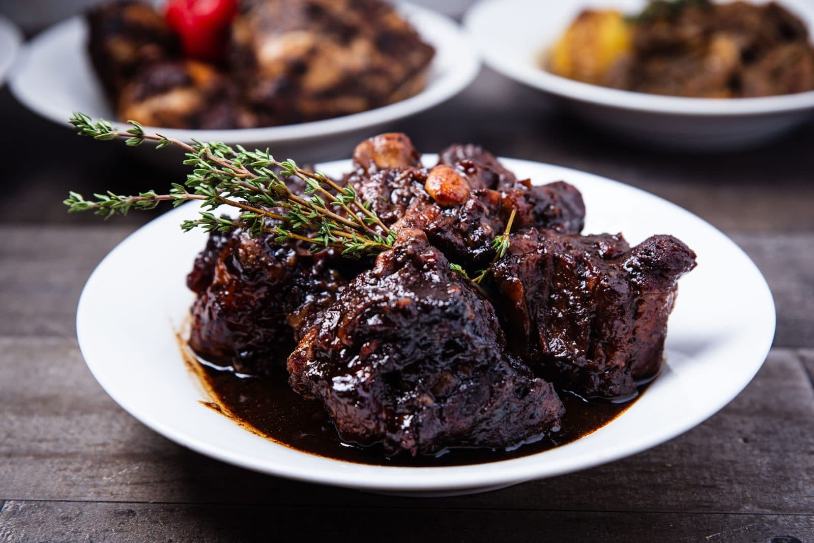 Slow-cooked meat in sauce garnished with thyme