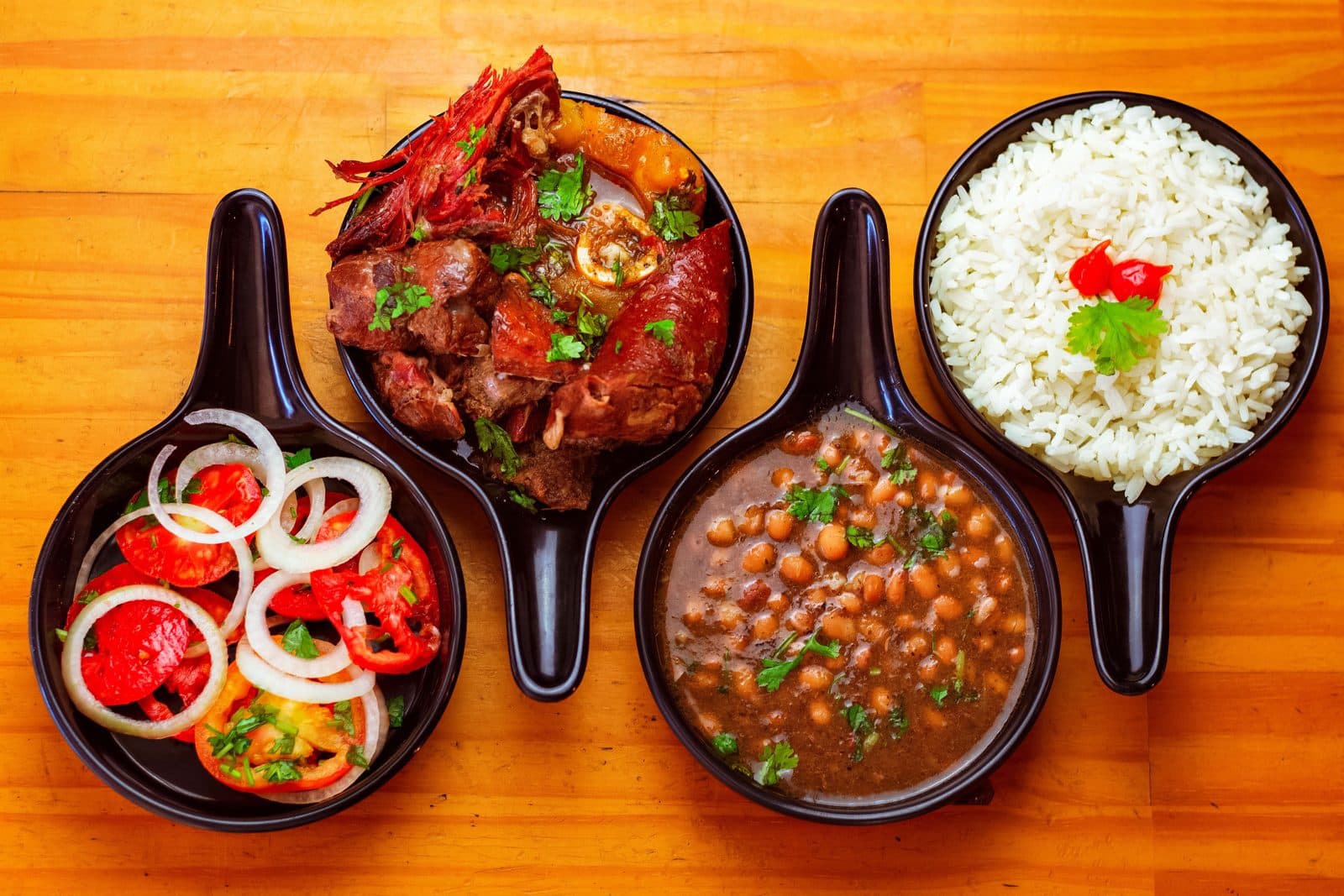 Viande, haricots, riz et vinaigrette servis dans des poêlons