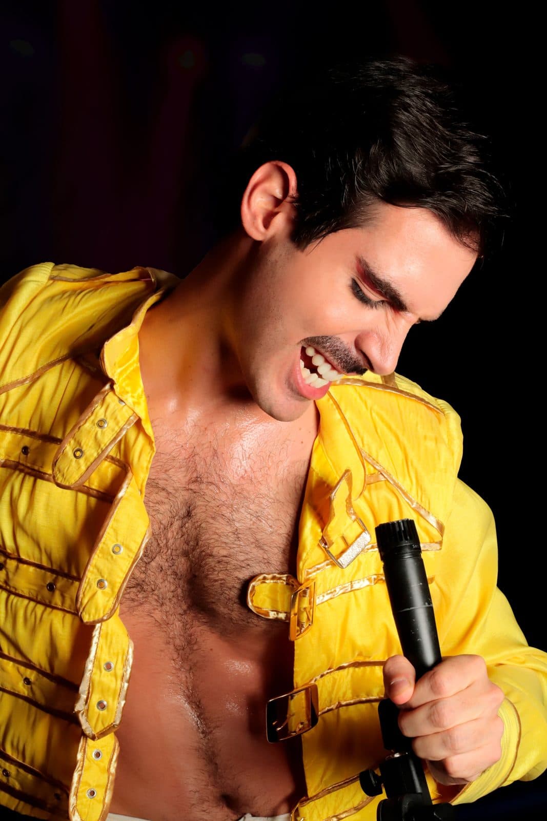 Singer in a yellow jacket performing a tribute show