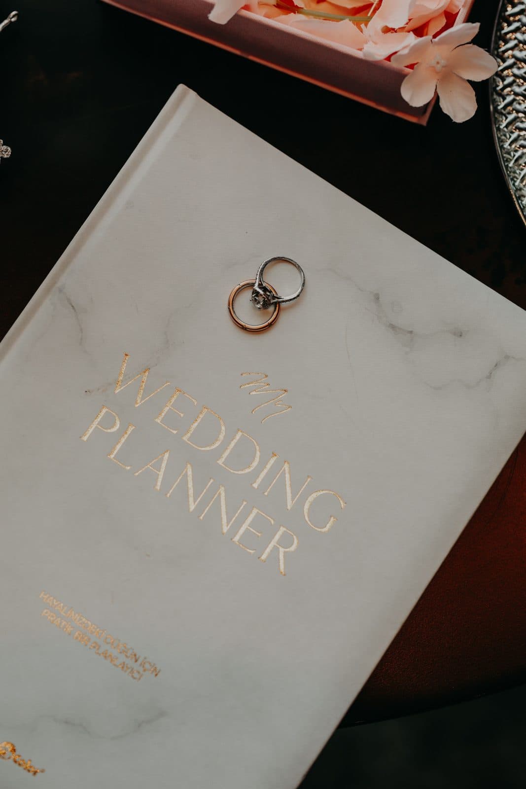 Carnet d'organisation de mariage avec deux alliances posées dessus