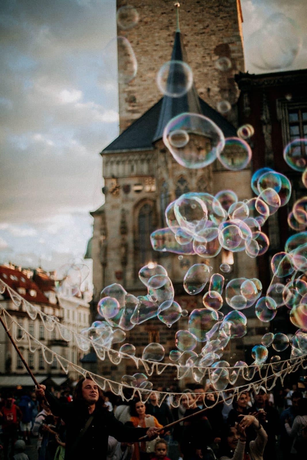 Cloud of soap bubbles above a crowd in a town square