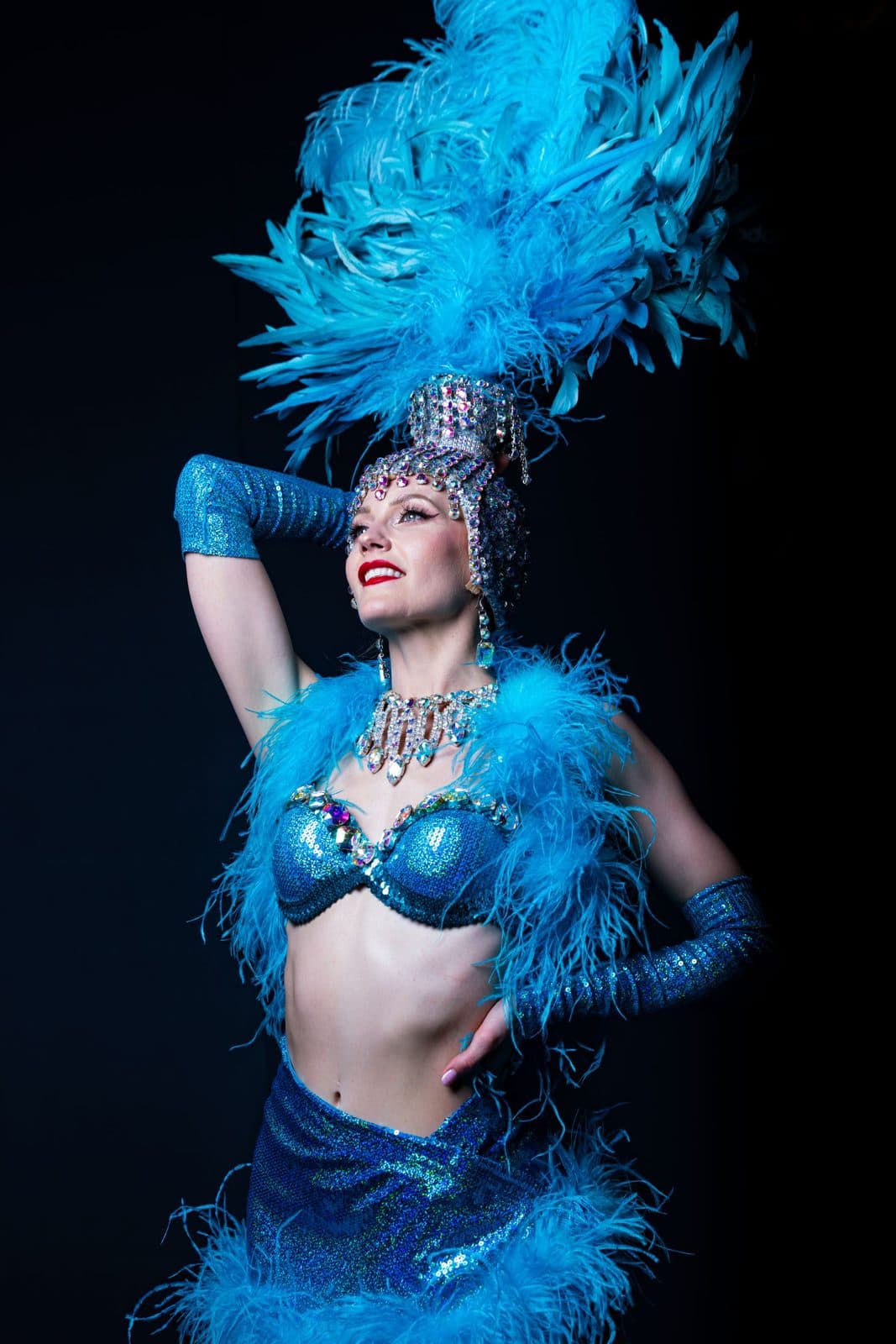 Showgirl in a blue feathered costume