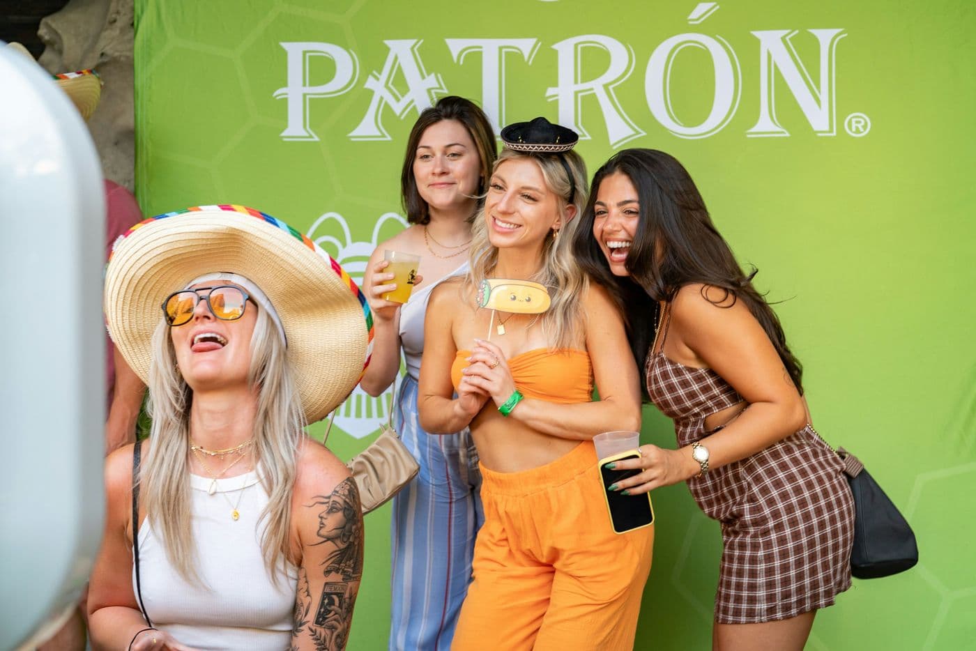 Friends laughing at a photo booth with hats and props